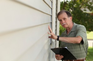 Adult male inspects home siding
