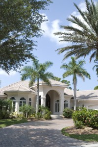 Florida home with grand entrance, arched windows, among palm trees