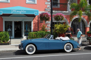 Two men talking on sidewalk in Naples, Florida, vintage convertible car in foreground