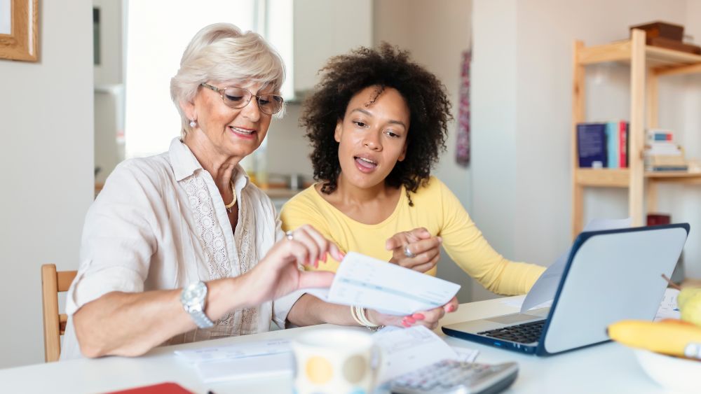two women paying bills - canva